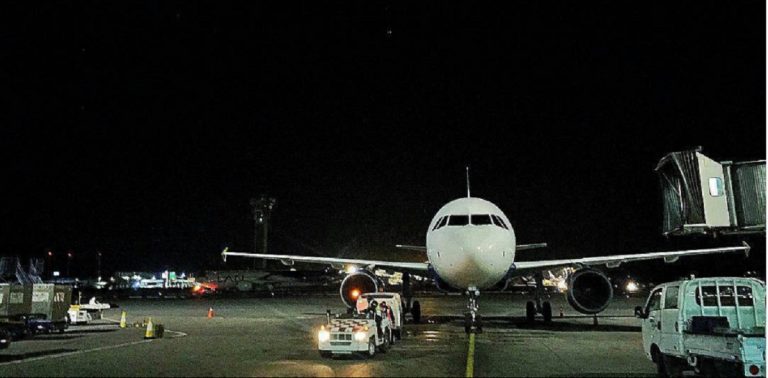 Avión esperando por la noche en el aeropuerto