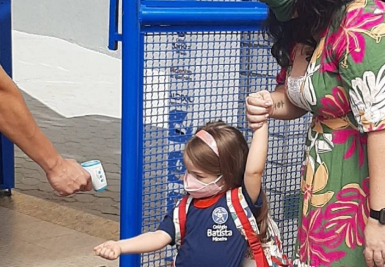 Toma de temperatura a una niña a la entrada de un colegio