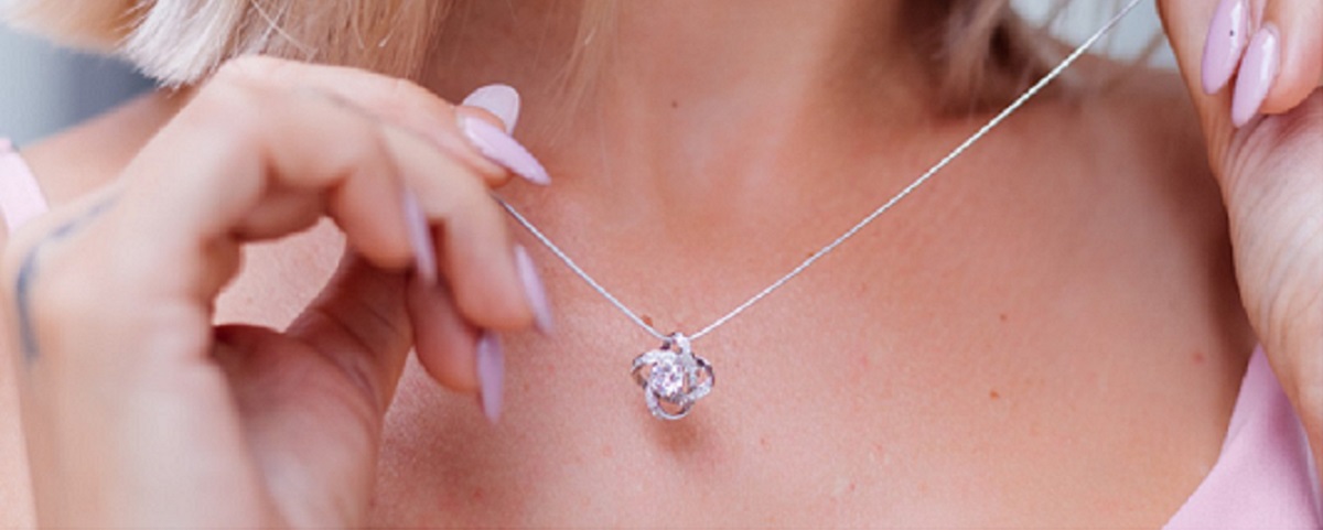 3 outdoor ritratto di donna in abito romantico rosa che indossa collana 1 1