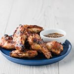 Alitas de pollo Teriyaki con salsa en la parte superior de la mesa blanca