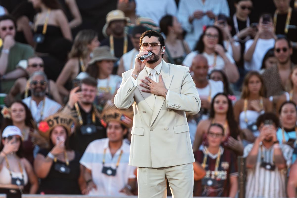 Artista sul palco durante esibizione in concerto internazionale, pubblico in platea