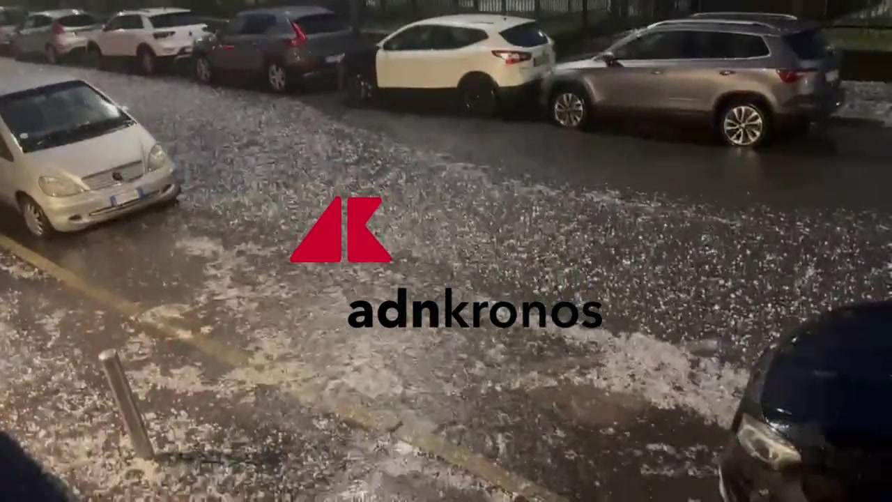 Migliaia di persone all'aperto durante temporale, riparo di emergenza, palco e strutture dell'ippodromo sotto acqua, immagine di approfondimento