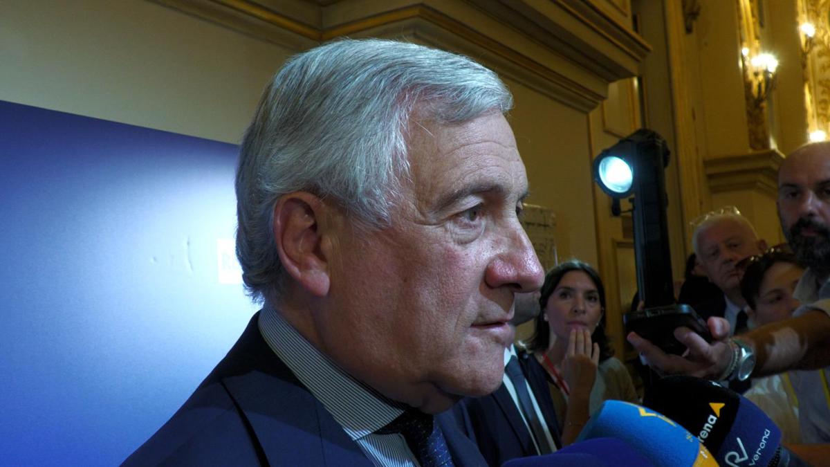 Tavolo riunione con bandiera italiana, discussione su strategie culturali internazionali