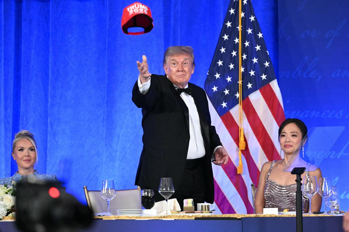 Uomo con cappellino rosso durante annuncio pubblico di candidatura presidenziale, momenti di tensione in sala stampa, immagine di approfondimento