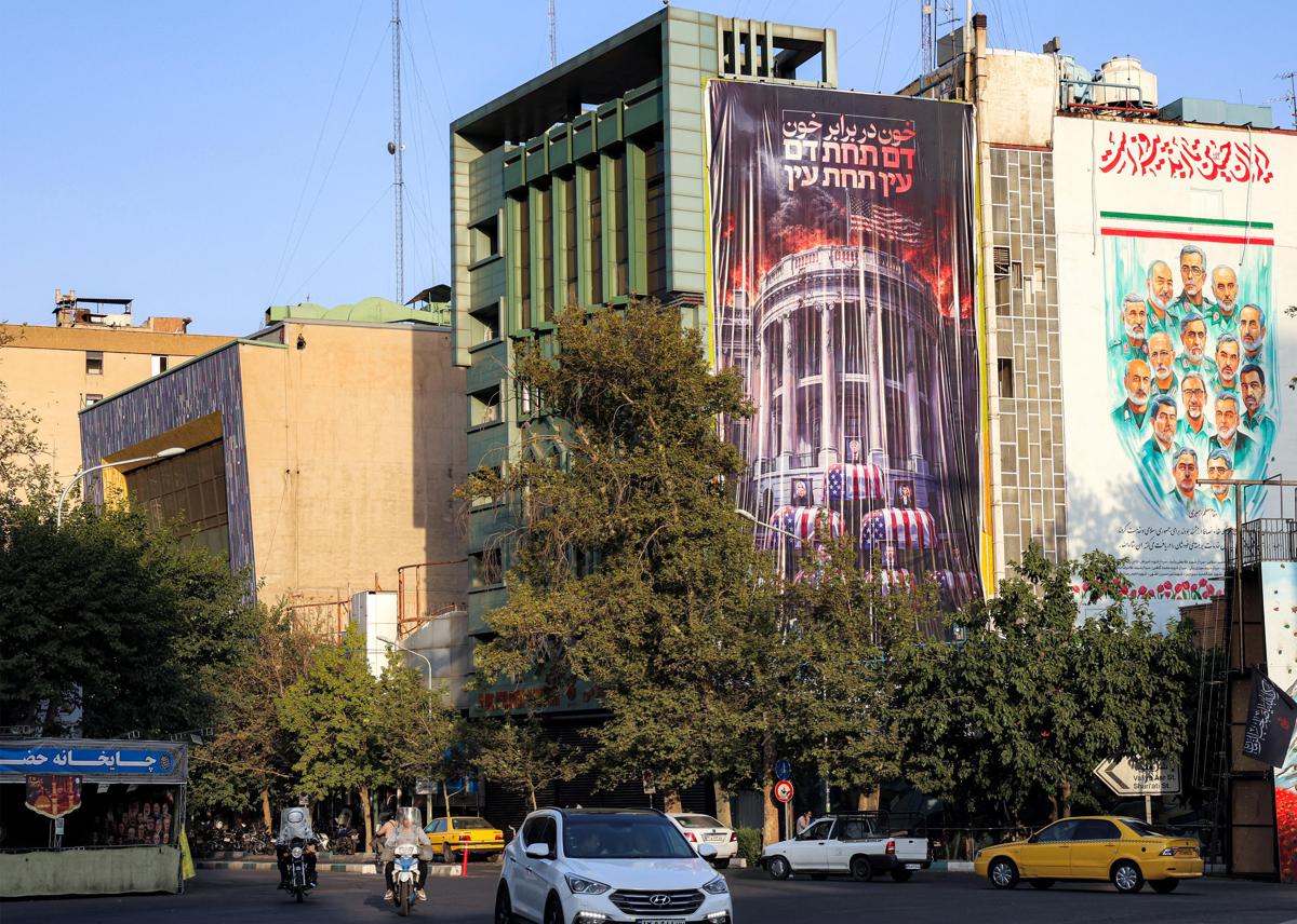 Strada di Teheran con murali e manifesti politici sugli edifici