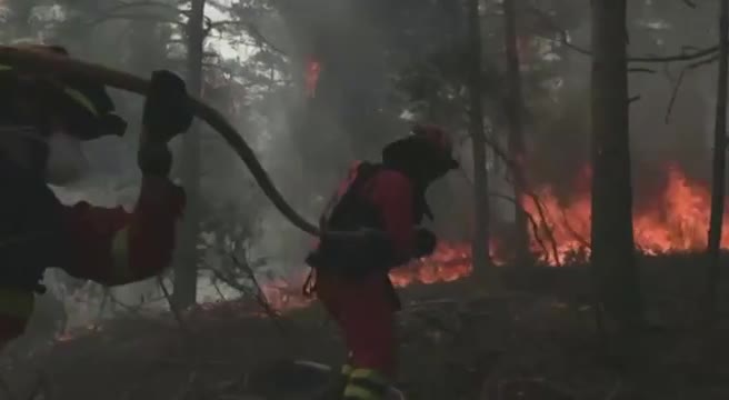 Vigili del fuoco e aerei antincendio operano contro un vasto incendio boschivo in Spagna nord di Madrid, case evacuate