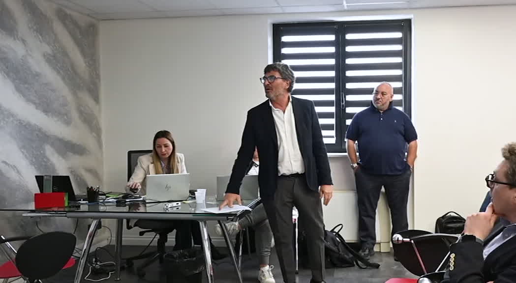 Sala riunione con dirigenti sportivi in conferenza stampa, tavolo con microfoni, immagine di approfondimento