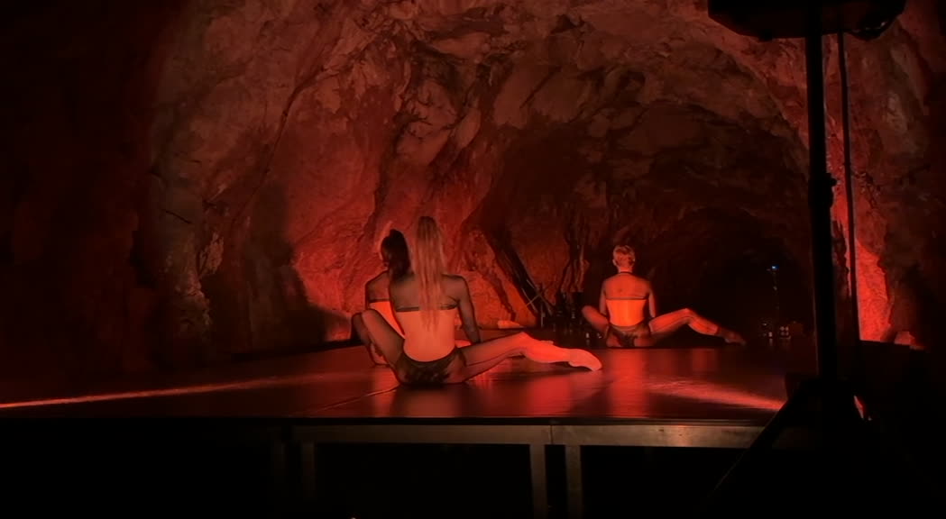 Performer in scena durante esibizione di danza contemporanea in spazio buio e minimale, immagine di approfondimento