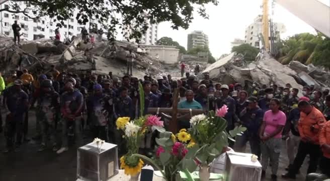 Abitanti riuniti in chiesa per preghiera e candele, con fiori e processione nelle strade di La Guaira, immagine di approfondimento