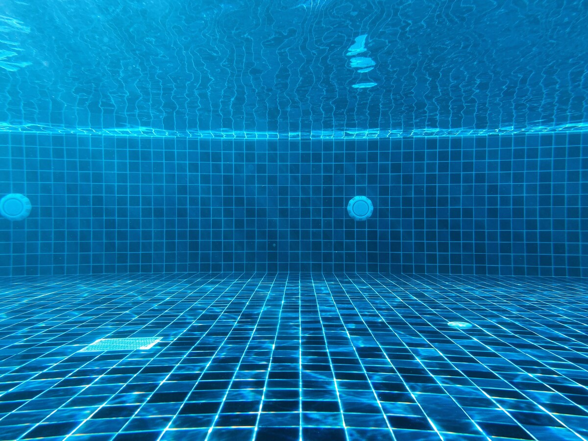 Vasca di piscina vuota con dettaglio di bocchettone di aspirazione sul fondo, immagine di approfondimento