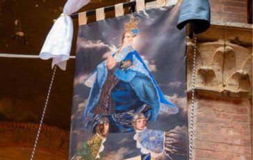 Palio di Siena 16 agosto il Drappellone fa discutere polemiche sul volto della Madonna androgina 364x230