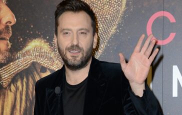 Cesare Cremonini saluta con la mano durante un evento