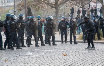 Poliziotti in assetto antisommossa affrontano manifestanti durante una protesta a Parigi