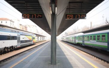 Stazione ferroviaria con due treni in attesa sui binari