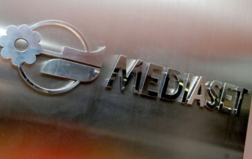 Logo Mediaset in metallo con fiore e scritta