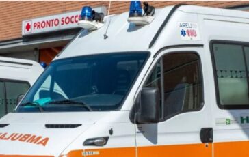 Ambulanza bianca con luci blu parcheggiata davanti al pronto soccorso