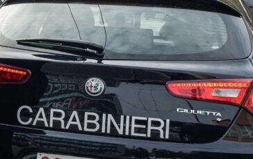 Auto dei carabinieri con la scritta 'Carabinieri' e il logo dell'Alfa Romeo, parcheggiata in Piazzale Fratelli Zavattari a Milano durante il lockdown.