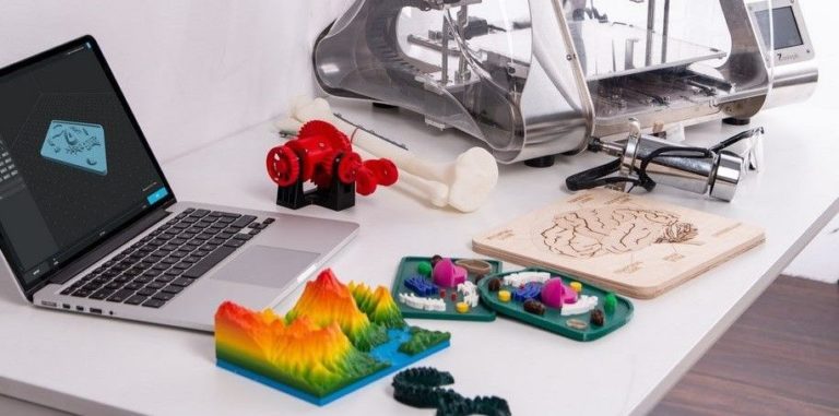 3d printed objects an mac on desk 2